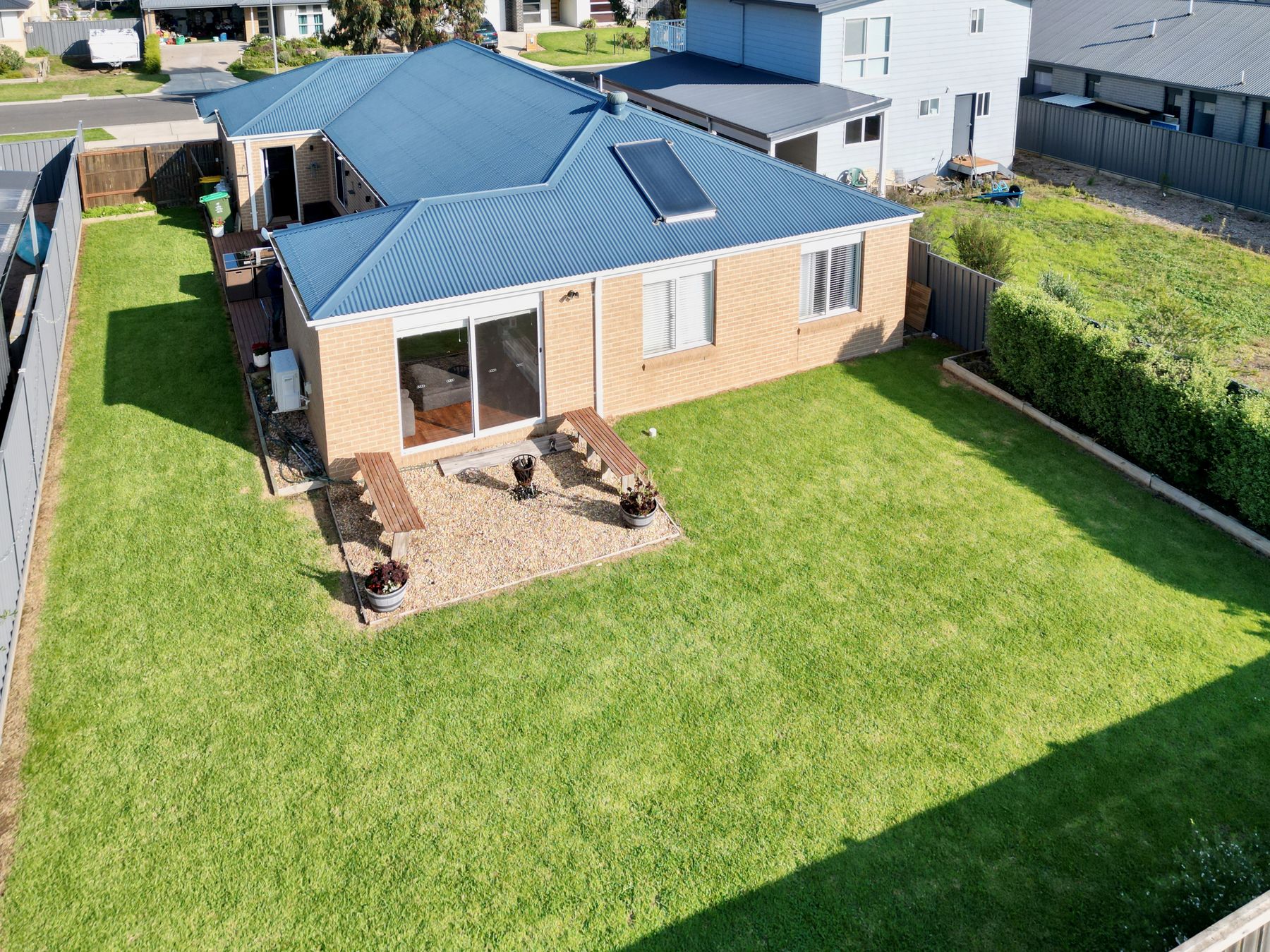 Aerial view of the property's backyard and blue roofline