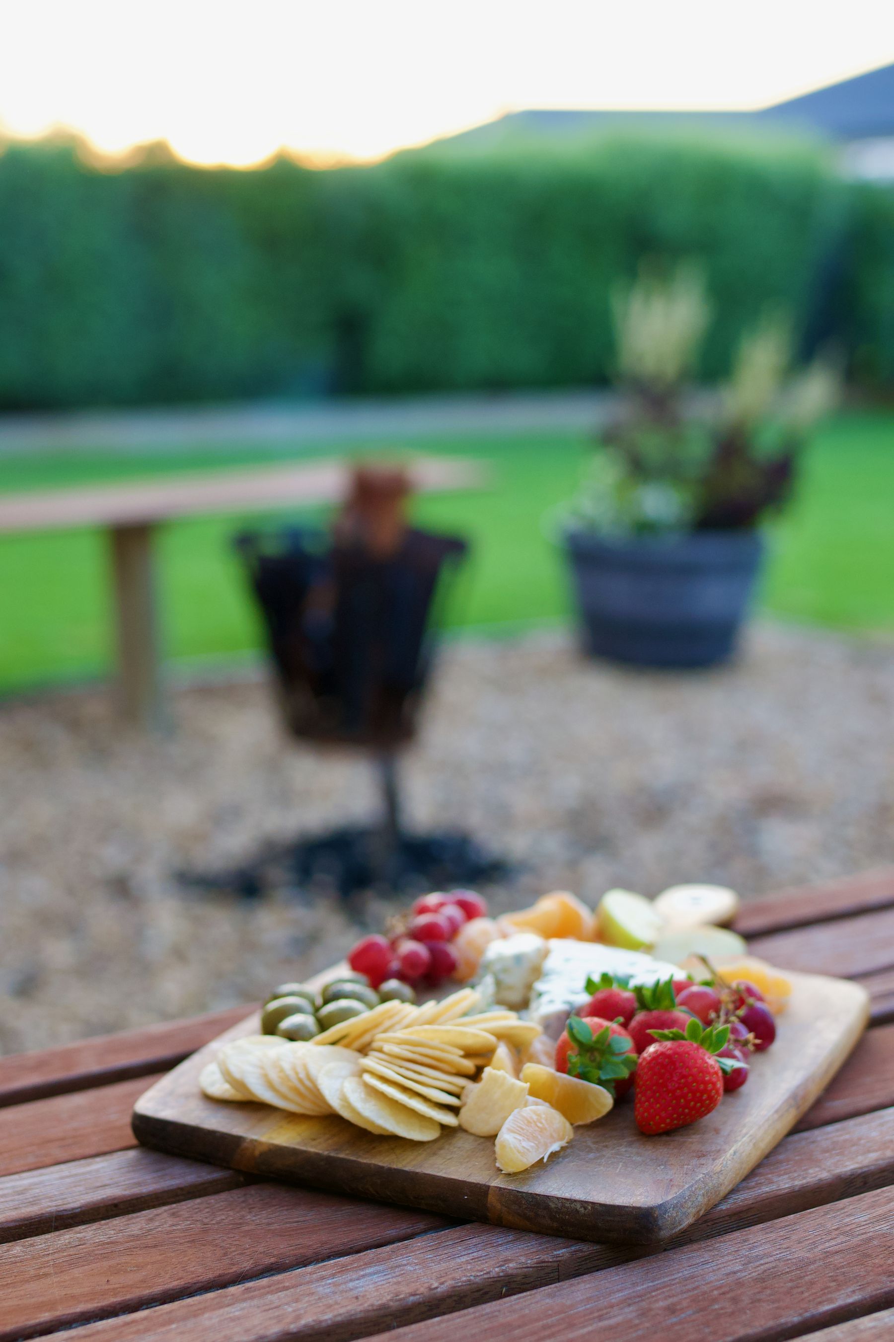 Cheese board with fruit and crackers at dusk