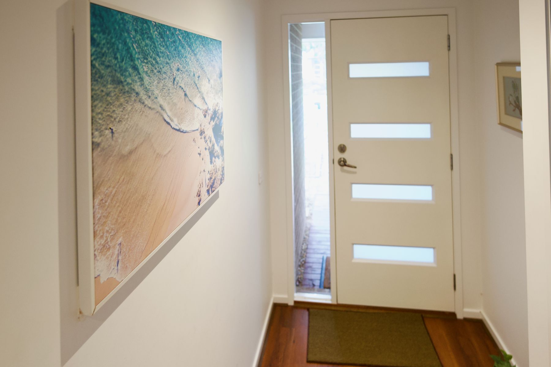 Entry hallway with an aerial beach print